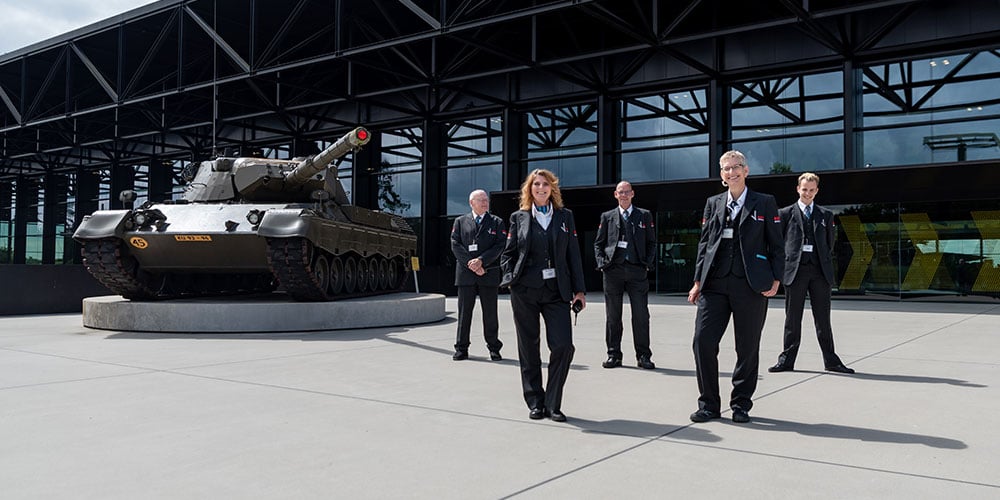 Group of security employees next to tank