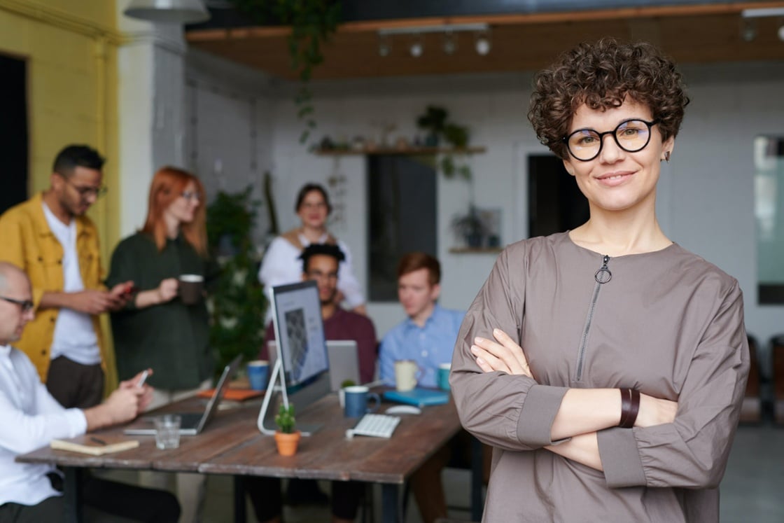 vrouw staat in een kantoor met haar team