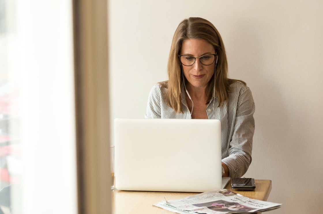 vrouw met bril werkt geconcentreerd achter laptop